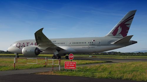 Airplane on runway against blue sky