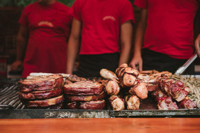 Meat on barbecue with people in background