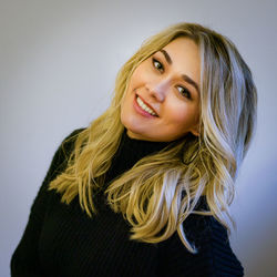 Portrait of young woman against wall