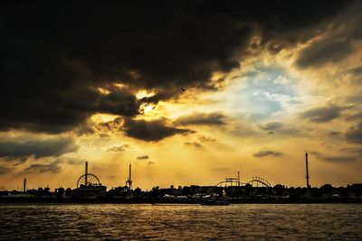 Silhouette of cranes at harbor during sunset