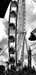 Low angle view of ferris wheel against cloudy sky