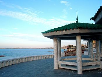 Gazebo on beach by sea against sky