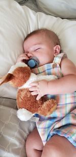 High angle view of baby girl lying on bed at home