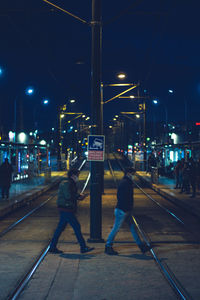People on railroad station platform at night
