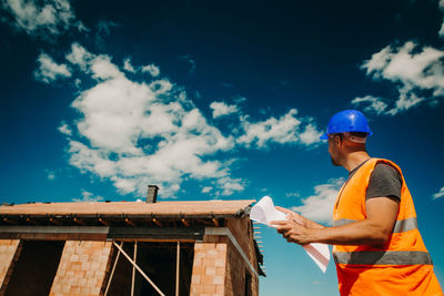 Man working at construction site against sky