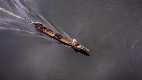 High angle view of people sitting on motorboat in river