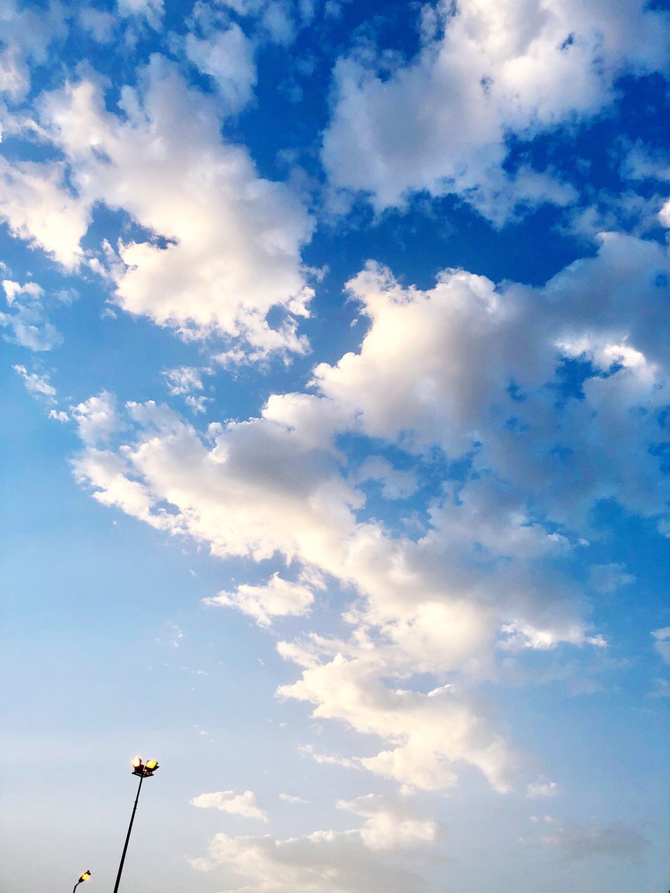 cloud - sky, sky, low angle view, lighting equipment, beauty in nature, street light, nature, no people, street, day, scenics - nature, tranquility, blue, outdoors, technology, tranquil scene, sunlight, light, idyllic, floodlight