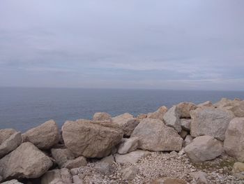 Rocks by sea against sky