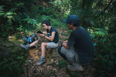 Full length of young man using mobile phone in forest