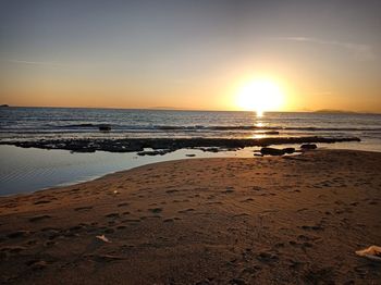 Scenic view of beach against sky during sunset