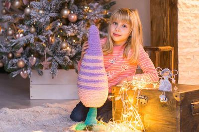 Full length of a girl holding christmas tree