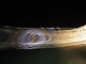 Low angle view of illuminated water against black background