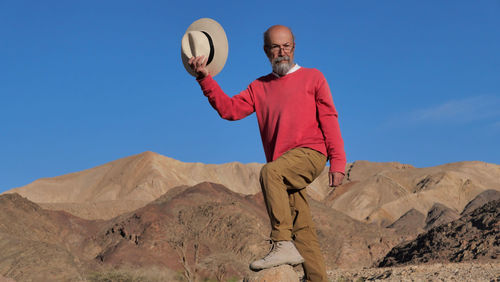 Senior man standing on rock in the desert 