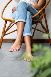 Woman sitting on wooden armchair on the balcony.