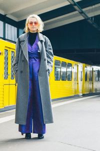 Portrait of woman standing at railroad station