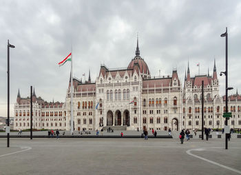 Buildings in city against cloudy sky