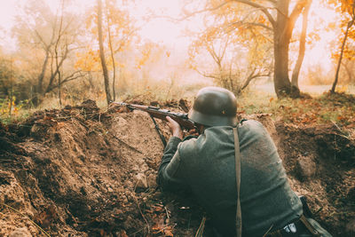 Rear view of man on field in forest