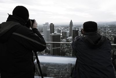 Rear view of man photographing cityscape