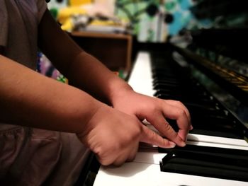 Cropped hands of child playing piano