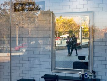 People walking on street seen through glass window