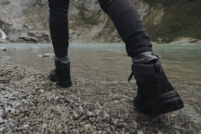 Low section of person walking by lake