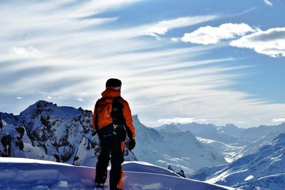 Rear view of a man standing on snow covered landscape