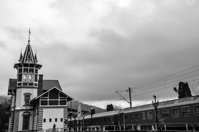 Train at railroad station against cloudy sky