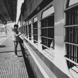 Side view of man standing at railroad station