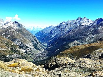 Scenic view of snowcapped mountains against clear blue sky