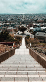 High angle view of staircase leading towards town against sky