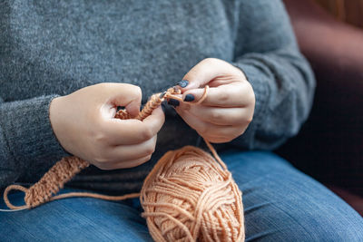 Midsection of woman knitting wool