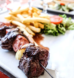 Close-up of meat with french fries served in plate