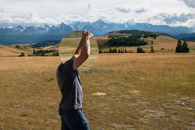 Man standing on field against mountains