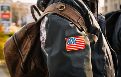 Person with backpack and jacket with flag of the united stats of america