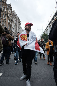 People standing on city street against sky