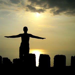 Silhouette woman with arms outstretched against sky during sunrise