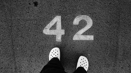 Low section of person standing on tiled floor