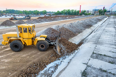 Earth mover at construction site against sky