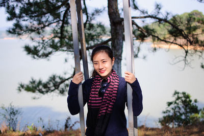 Portrait of a girl standing on swing