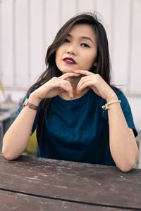 Portrait of young woman sitting on picnic table