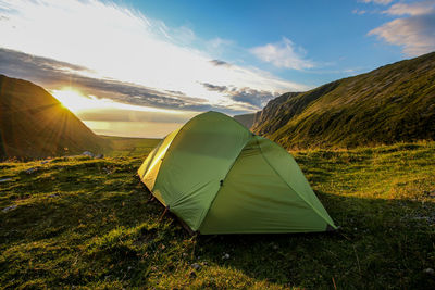 Tent on field against cloudy sky