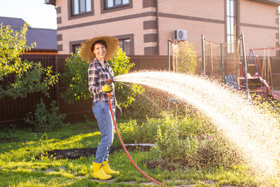 Full length of woman standing in yard