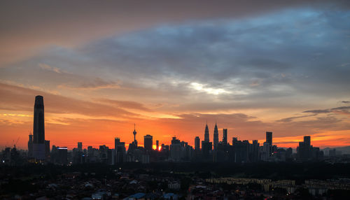 Silhouette buildings against sky during sunset
