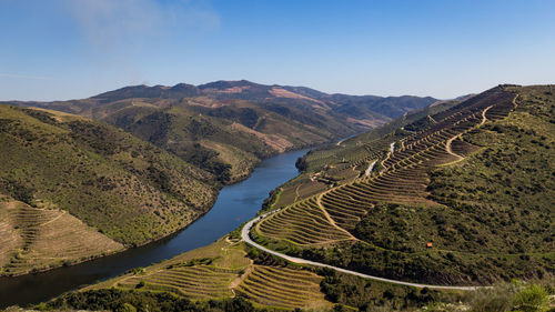 High angle view of field and mountains against clear sky