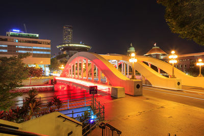 Illuminated buildings against sky at night