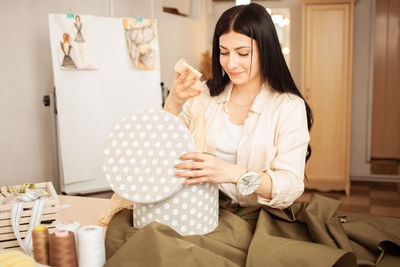 Seamstress in sewing studio, indoors. beautiful woman, cozy interior. young entrepreneur. 