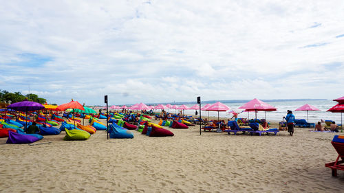 Group of people on beach against sky