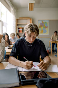 Teenage boy studying in classroom