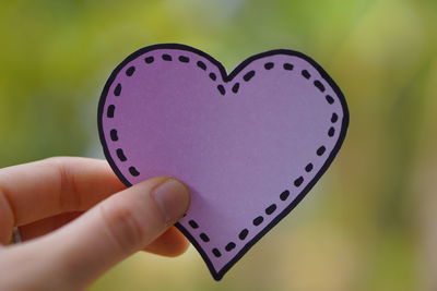 Close-up of woman holding heart shape hand