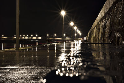 Reflection of illuminated street light in water at night